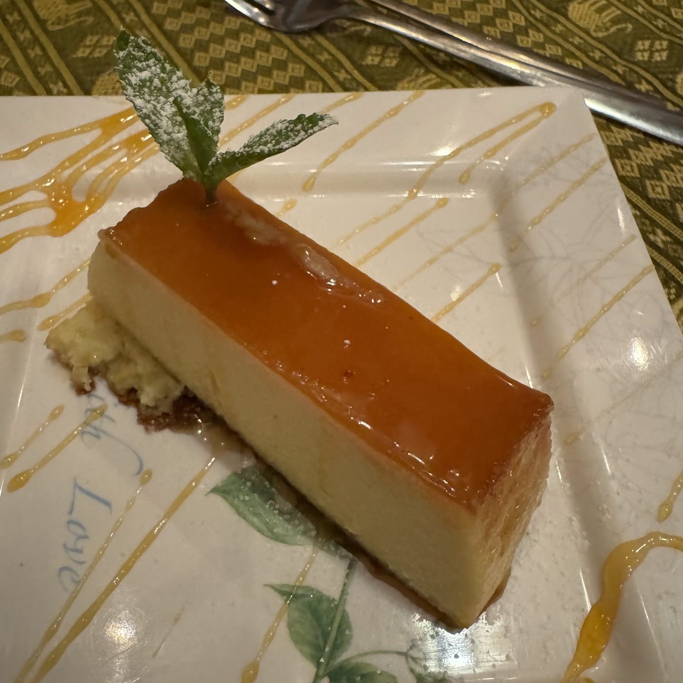 A slice of custard dessert with caramel and mint