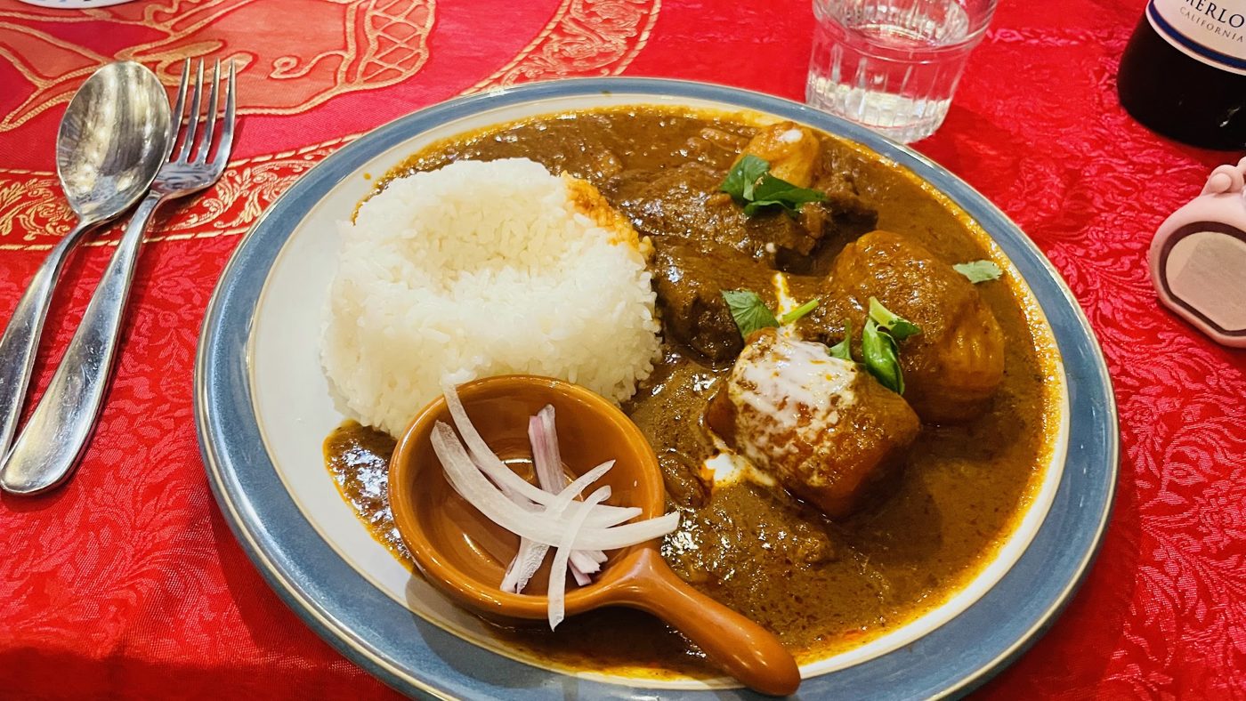 Massaman curry with rice on a blue-rimmed plate